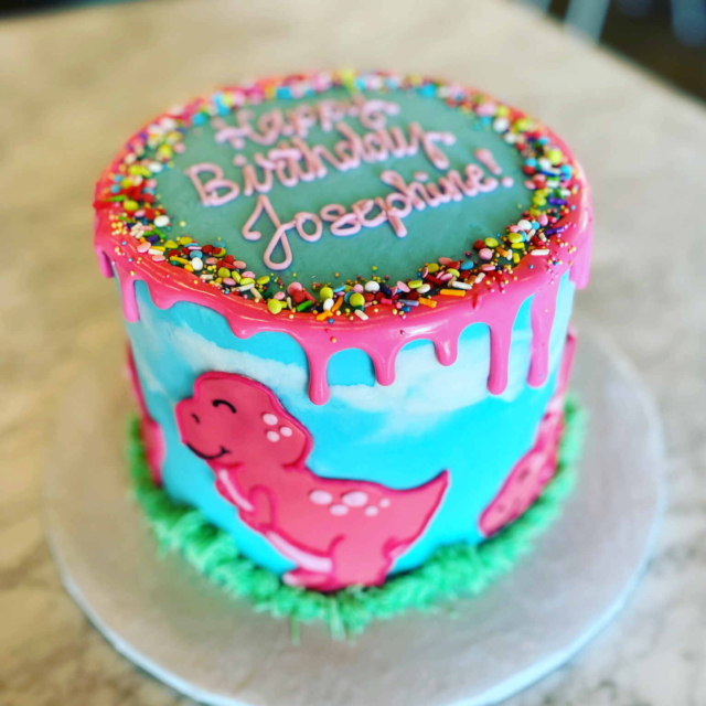 Dinosaur blue and green and pink sprinkle drip cake