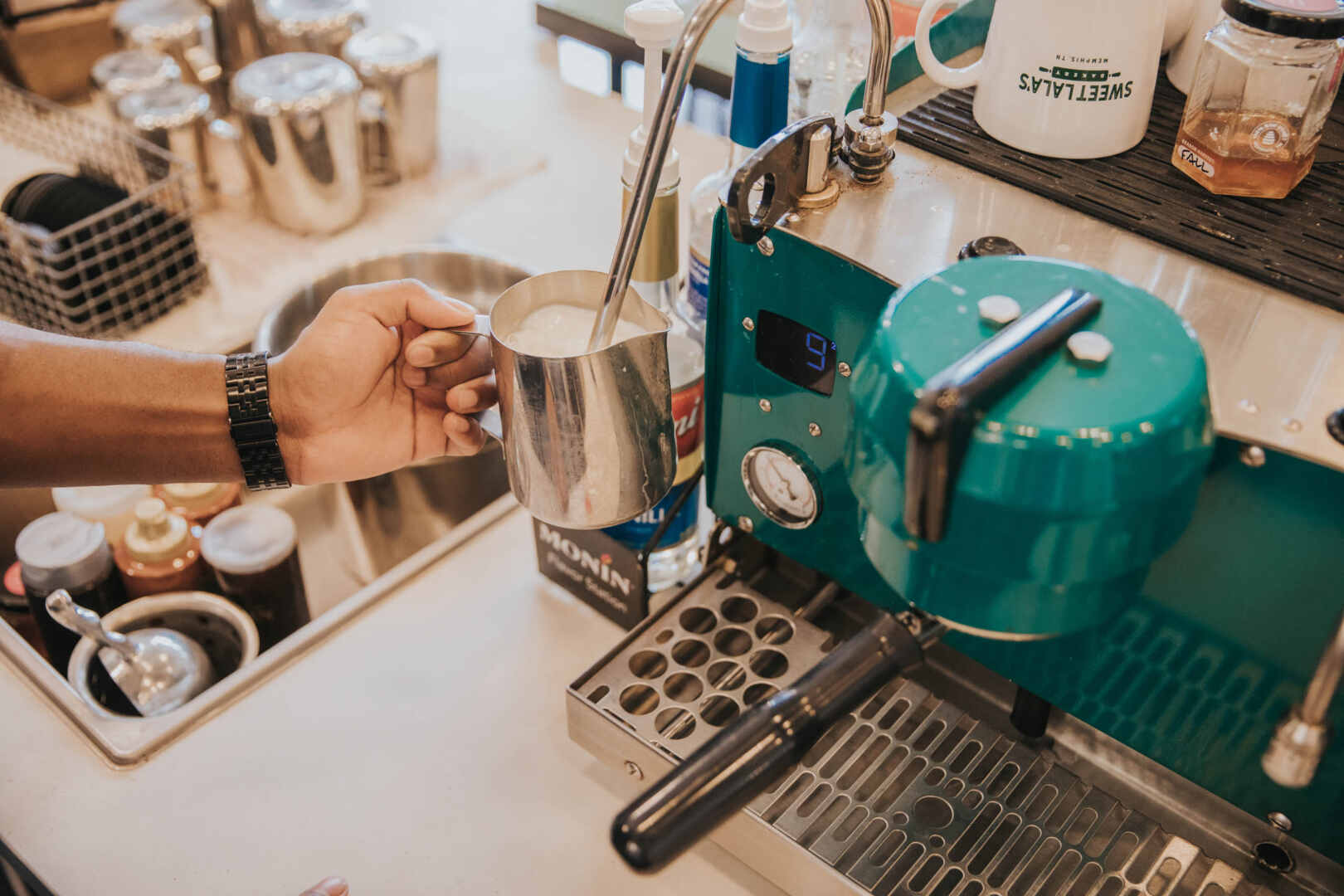 Barista making steaming milk for an espresso drink