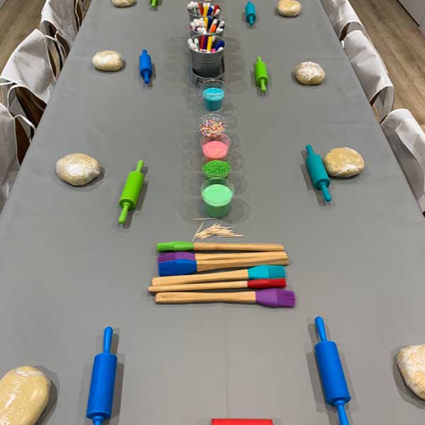 Table with rolling pins, icing brushes and dough. Memphis Bakery Party